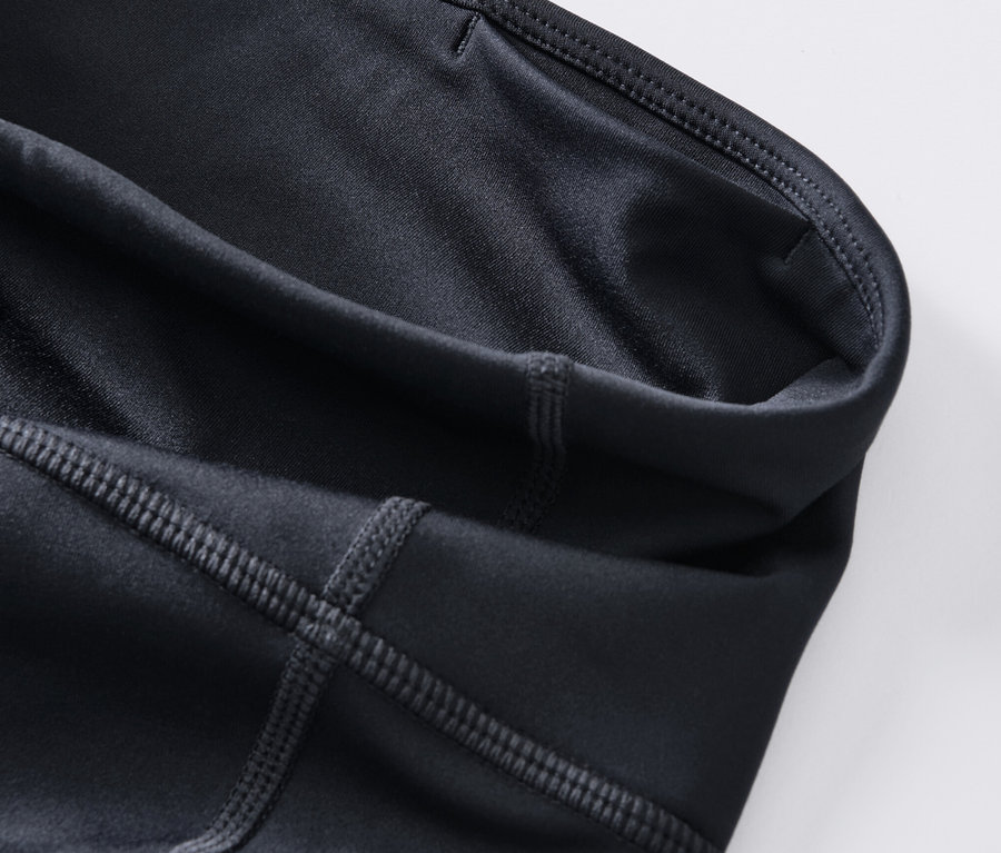 Egy sötétkék női 3/4-es sportnadrág részletének közeli képe.