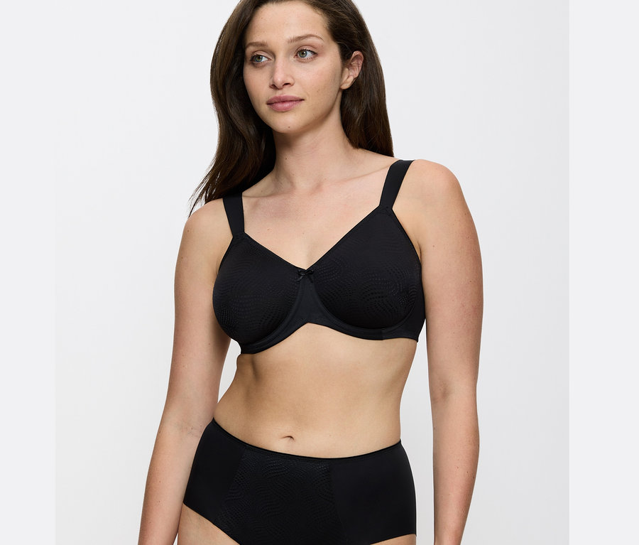 Portré egy fekete Triumph Essential »Minimizer W X« melltartót viselő nőről.