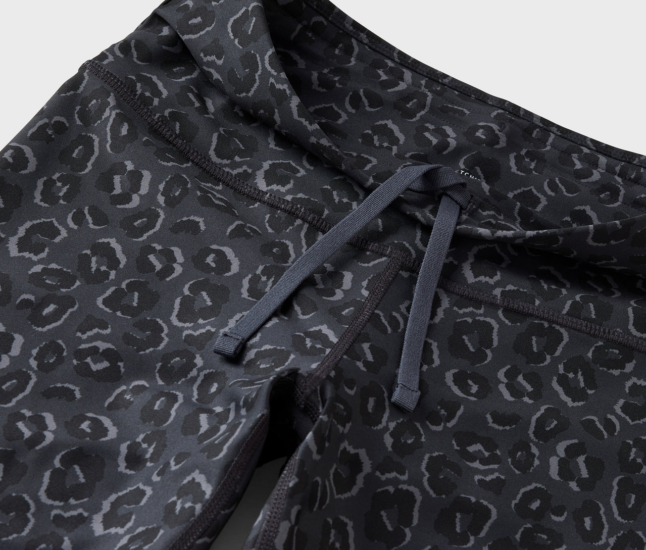 Női leggings részlete, húzózsinórral a derékban és állatmintával.