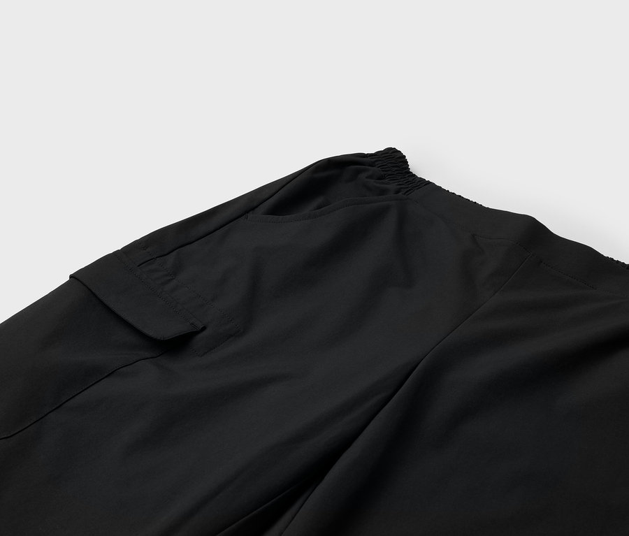 Fekete nadrág részlete oldalzsebbel és gumis derékpánttal.