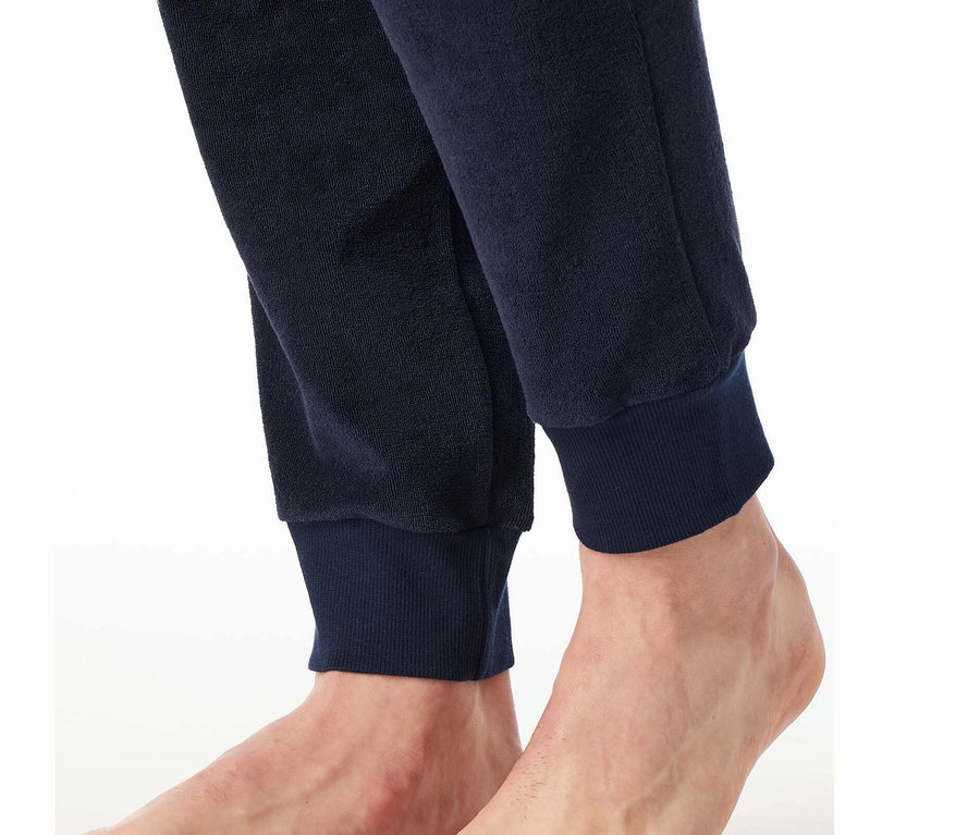 Egy sötétkék melegítőalsó alja és a hozzá tartozó lábak részletfotója.