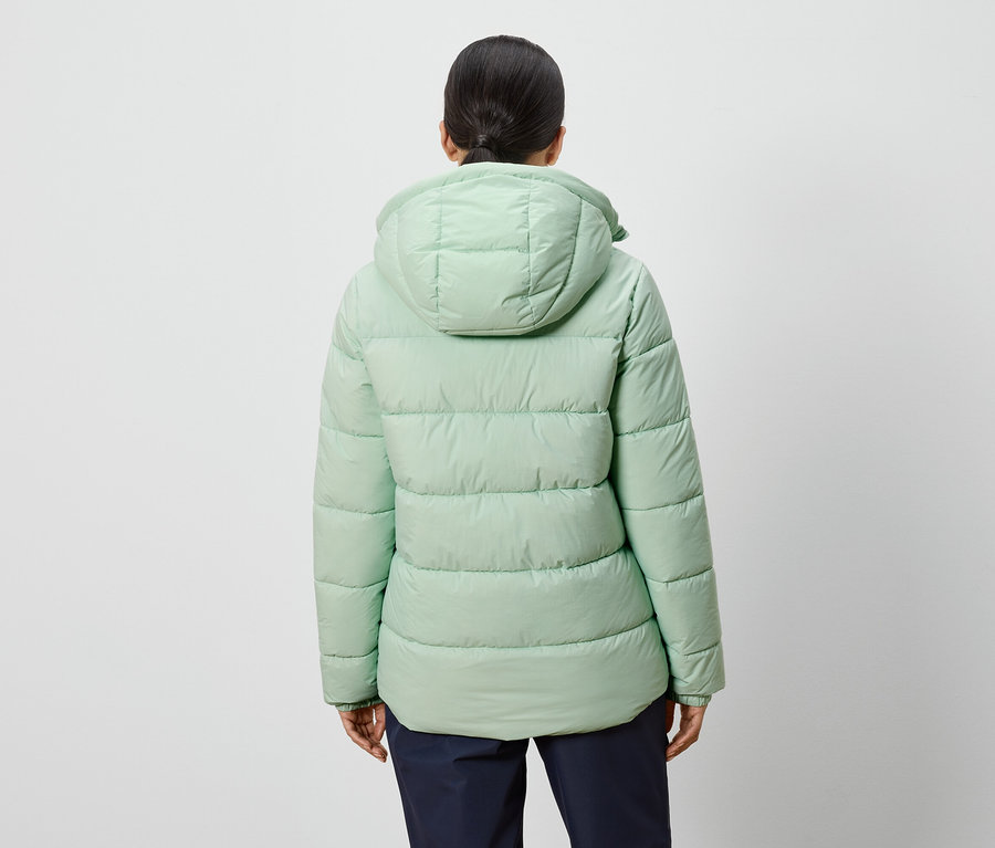 Hátulnézet egy világoszöld, kapucnis kabátot viselő nőről.