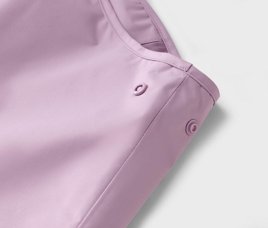 Egy lila esőkabát közeli képe patentokkal.