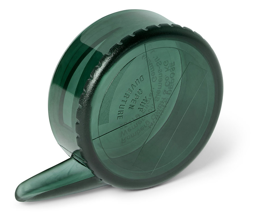 Egy zöld mérőpohár közeli képe egy fehér felületen.