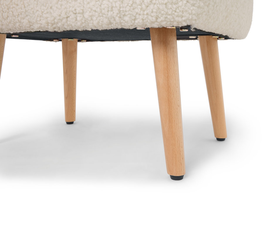 Egy természetes színű fa lábakkal és krémszínű, bozontos üléssel rendelkező széklet aljának közeli képe.