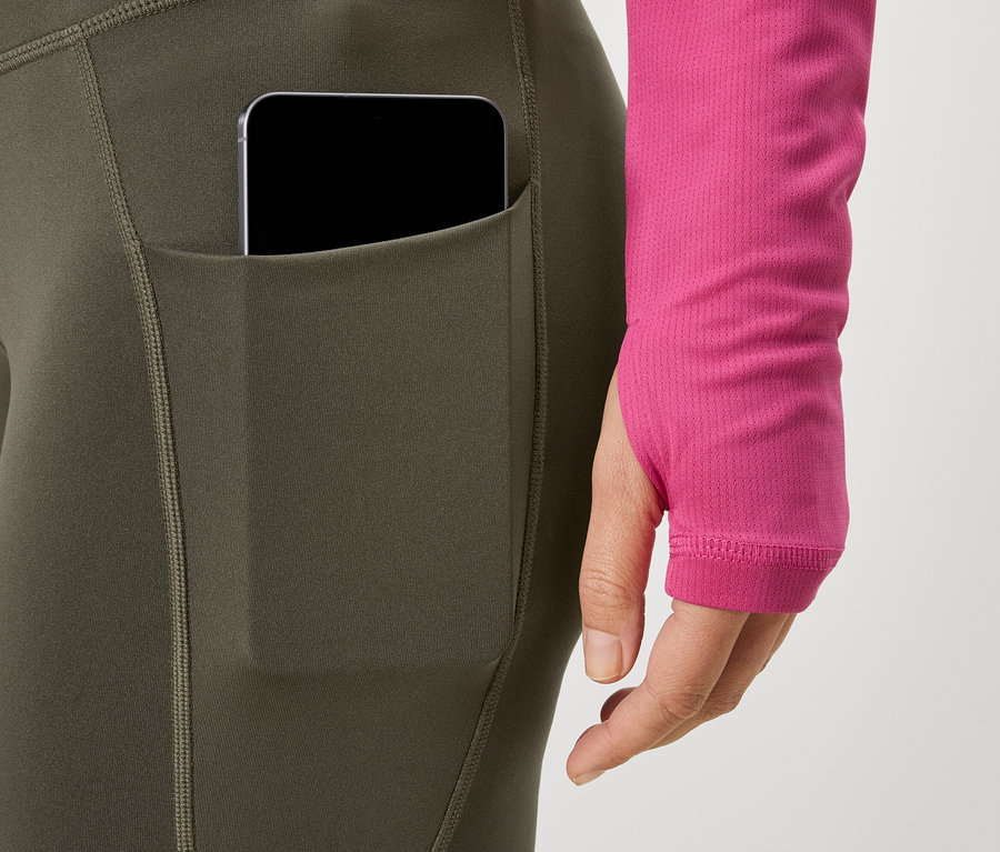 Nő visel telefontartós leggingst és rózsaszín felsőt.