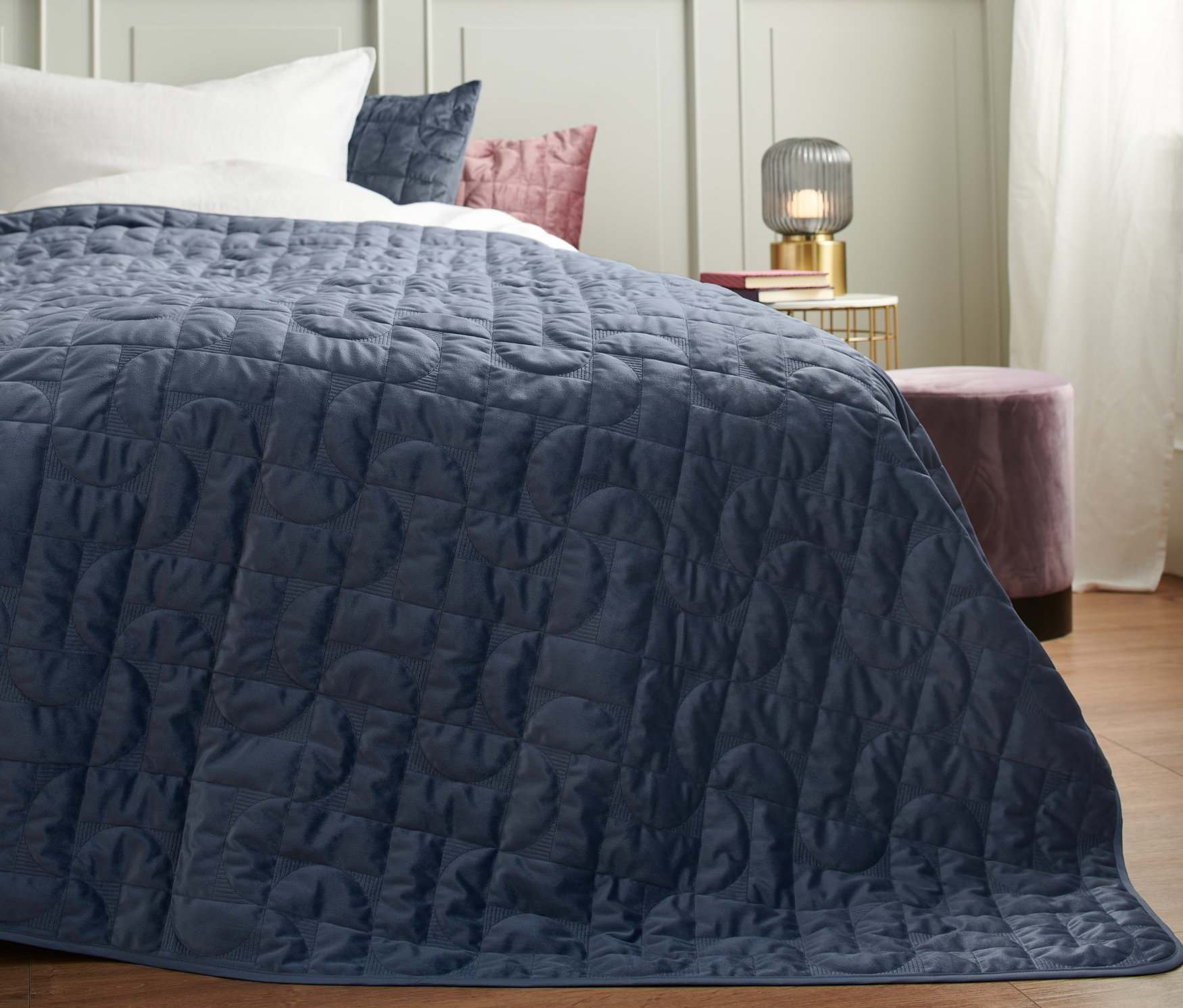 Kék bársony ágytakaró egy ágyon.