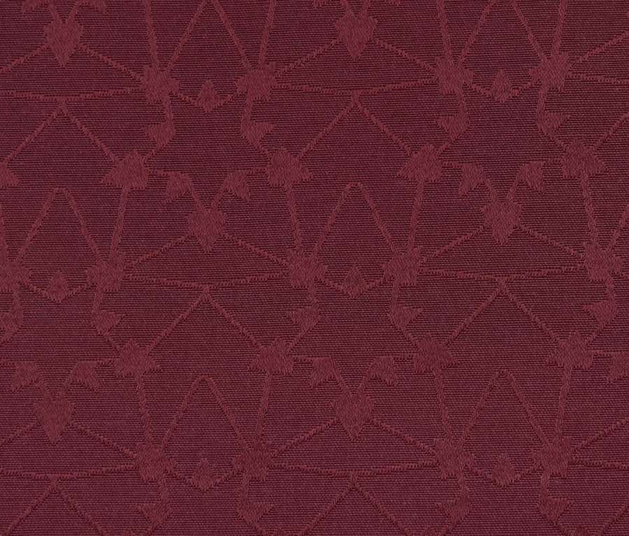 Egy piros, geometrikus mintás jacquard asztalterítő részlete.