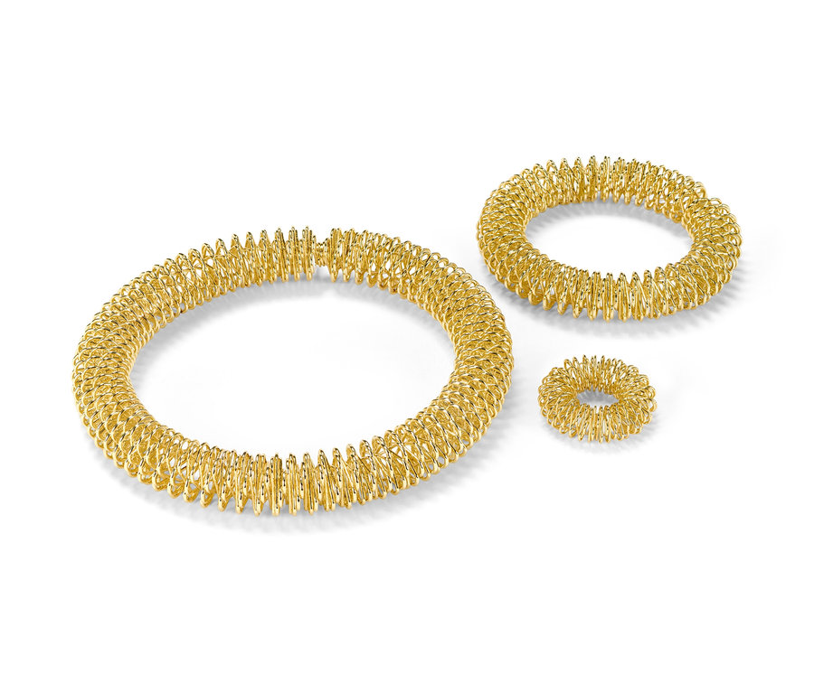 Arany akupresszúrás készlet fehér háttérrel.