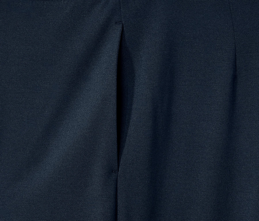 Egy sötétkék női jersey nadrág részletének közeli képe.