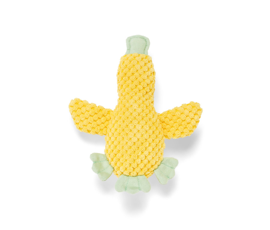 Egy sárga »kiskacsa« plüss kutyajáték világoszöld részletekkel fehér háttéren fekszik.