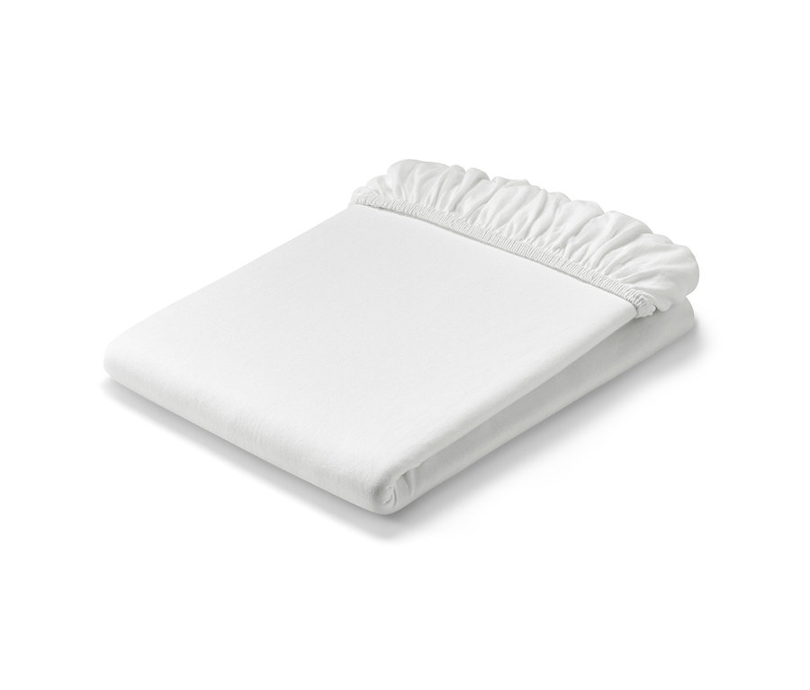 Összehajtott, fehér, gumis jersey lepedő.