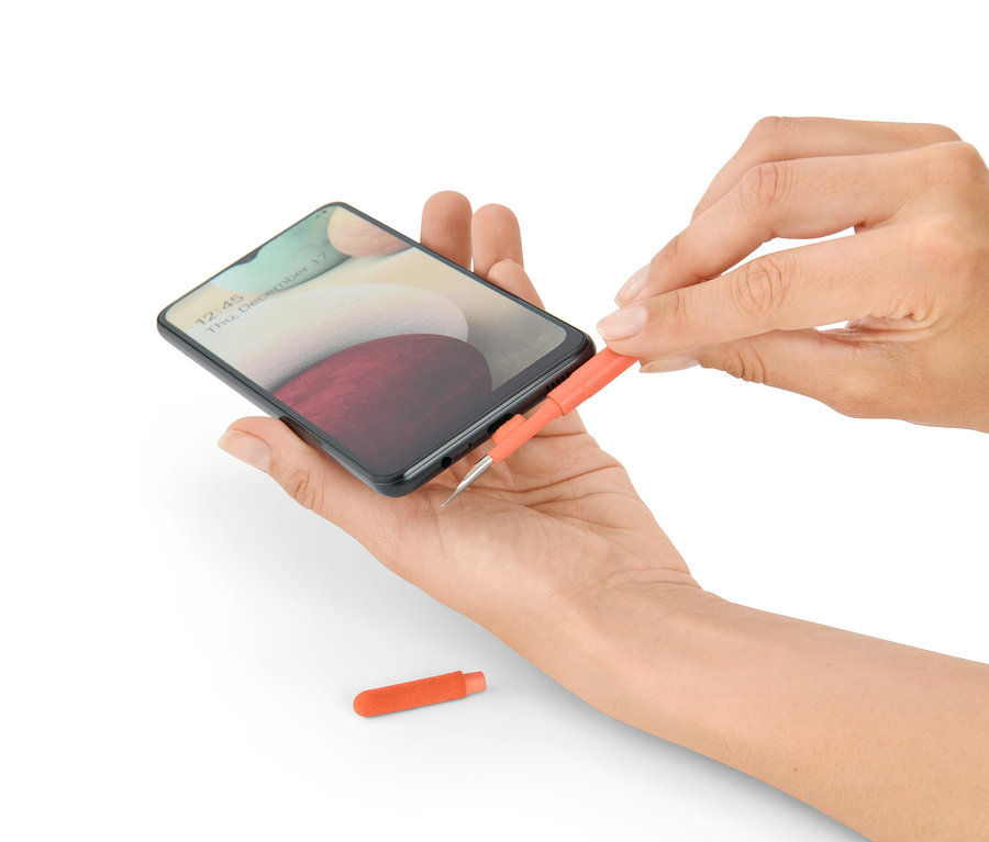 Egy nő egy telefont tisztít egy 4 az 1-ben elektronikai eszköz tisztítóval.