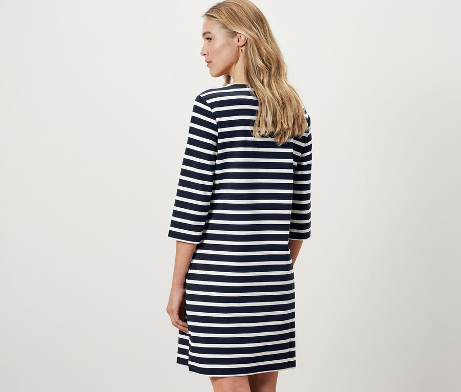 Hátulról látható nő csíkos női lezser ruhában.