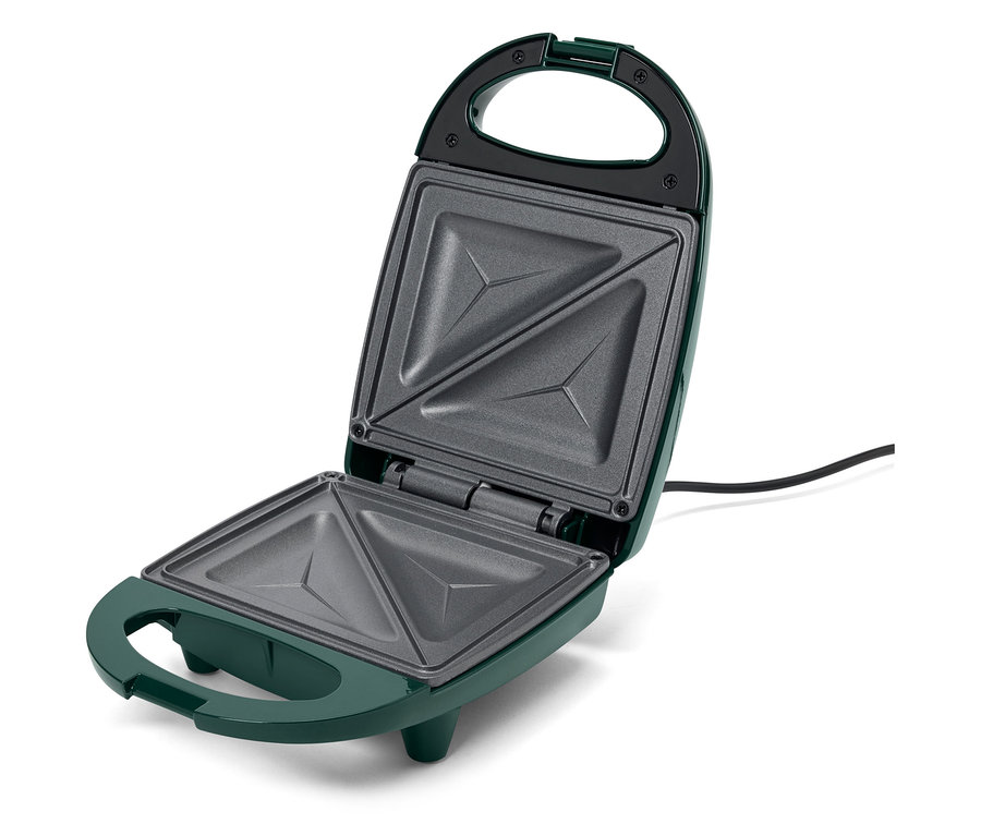 Egy nyitott, zöld szendvicssütő háromszög alakú mélyedésekkel.