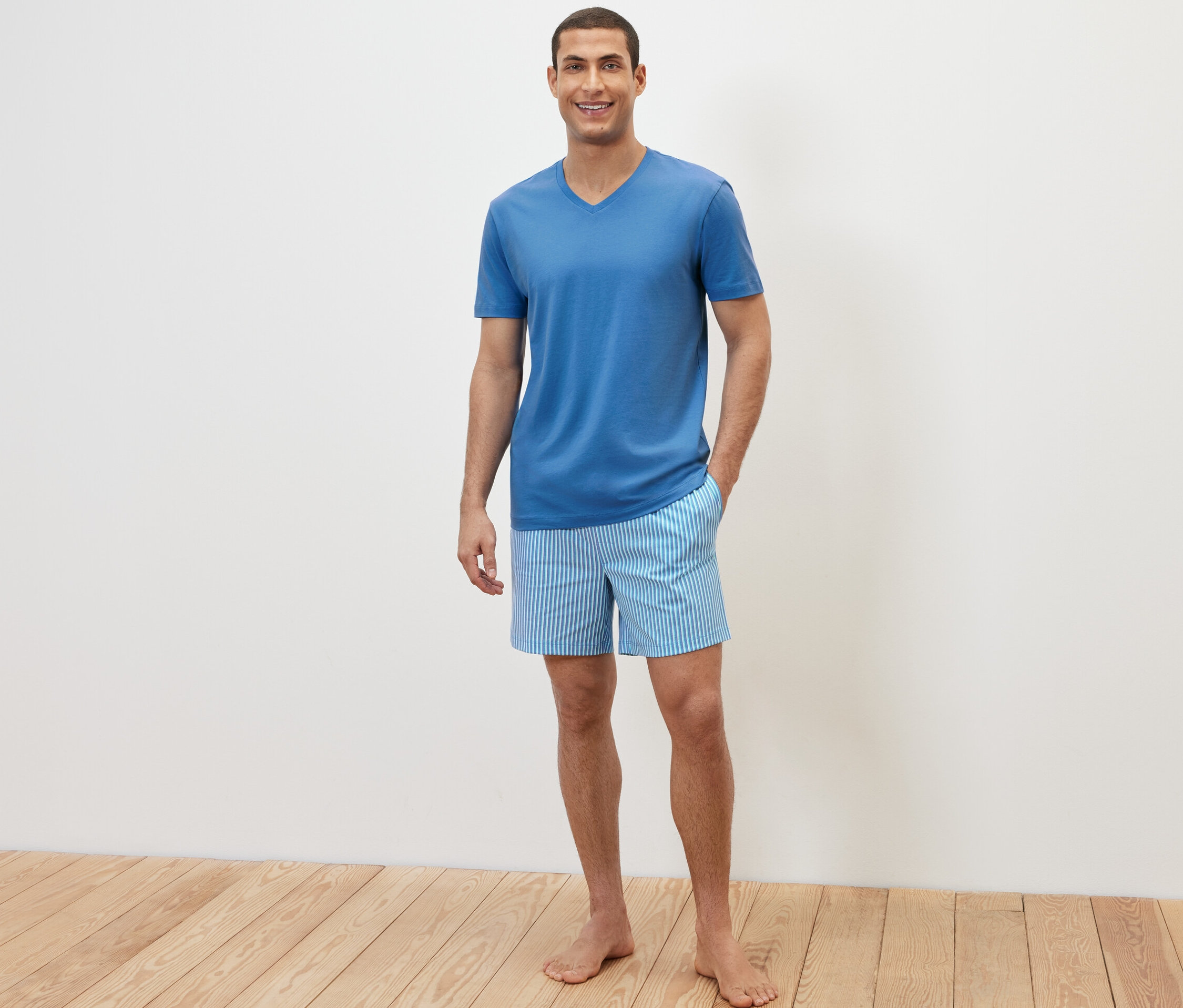 Férfi pózol egy rövidnadrágos pizsamában.