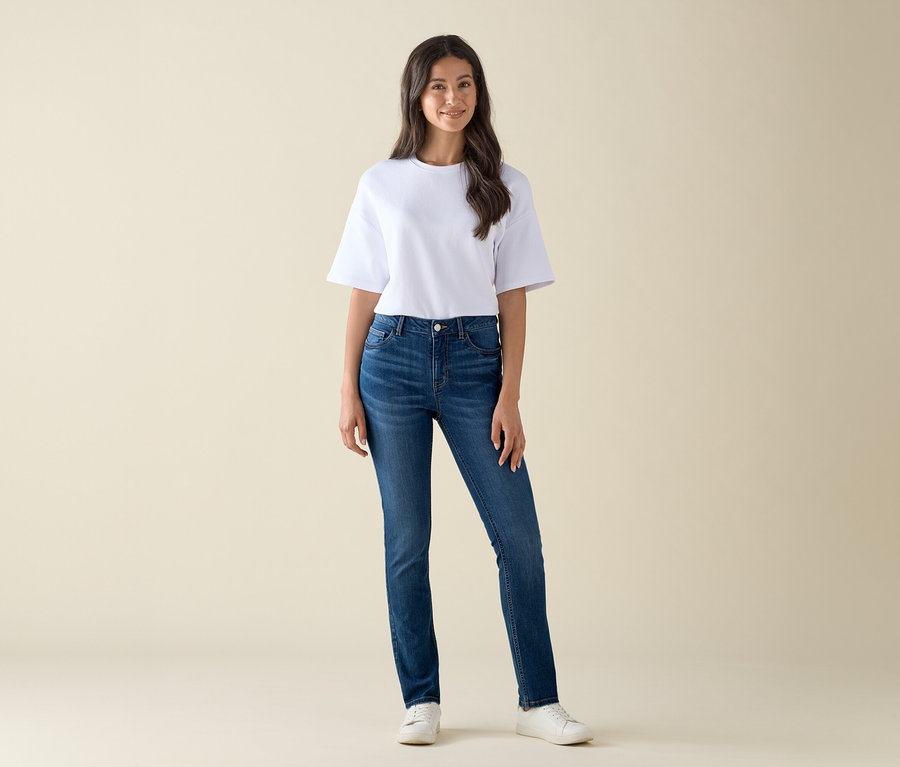 Egy nő áll, és Slim-Jeans – Fit »Emma« farmernadrágot visel középkék farmerben és egy fehér pólót.