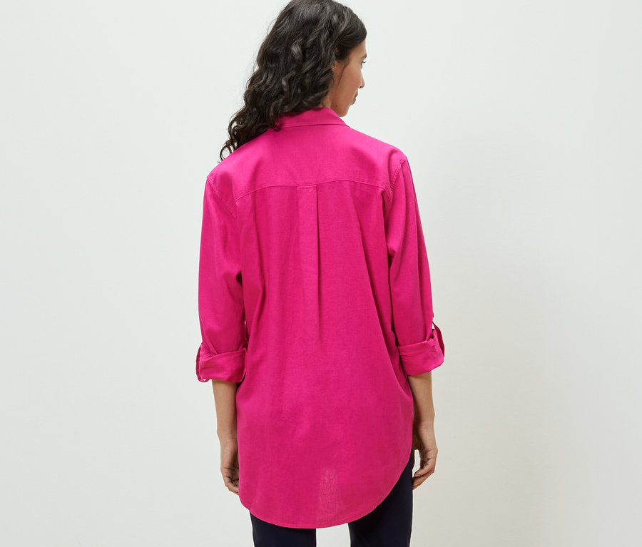 Nő visel egy rózsaszín, hosszú lenvászon blúzt.