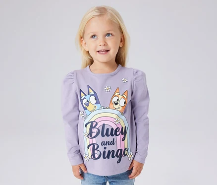 Egy lány lila NAME IT »BLUEY« hosszú ujjú gyerekfelsőt visel Bluey és Bingo nyomtatással.