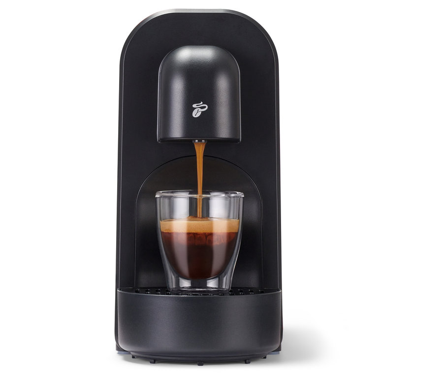 Az eszpresszó a fekete Cafissimo now red kávéfőzőből egy pohárba folyik.