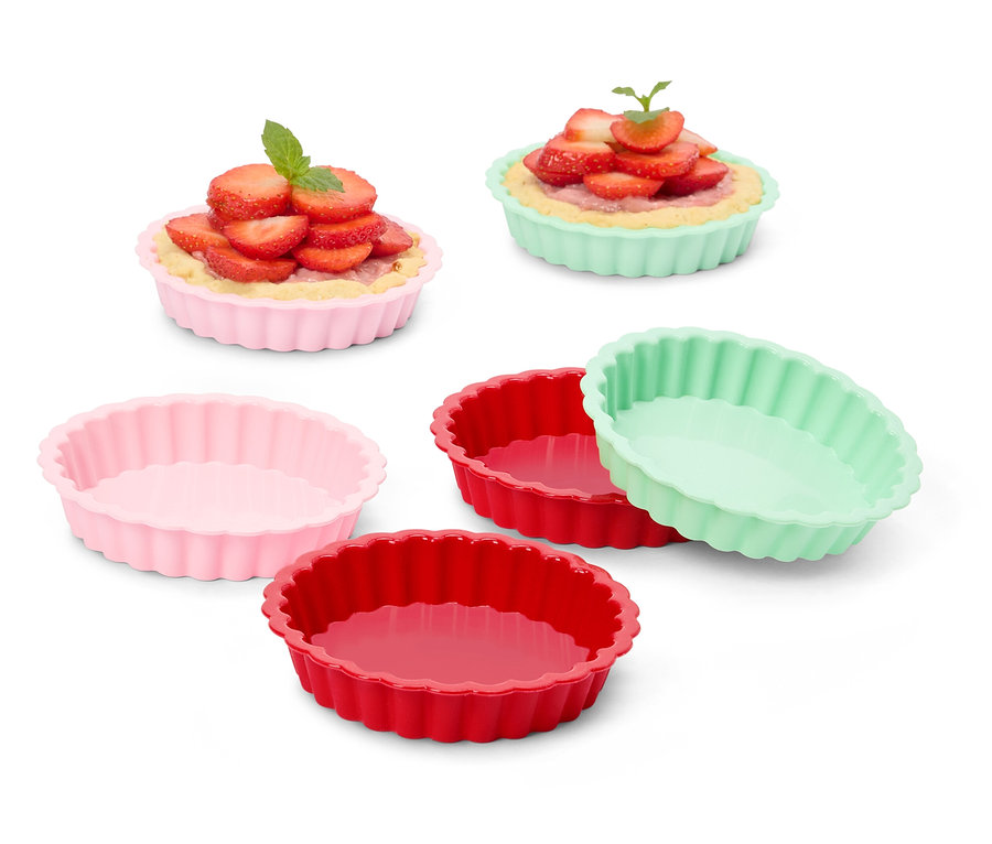 Több színes tortaforma, néhány epertortával töltve.