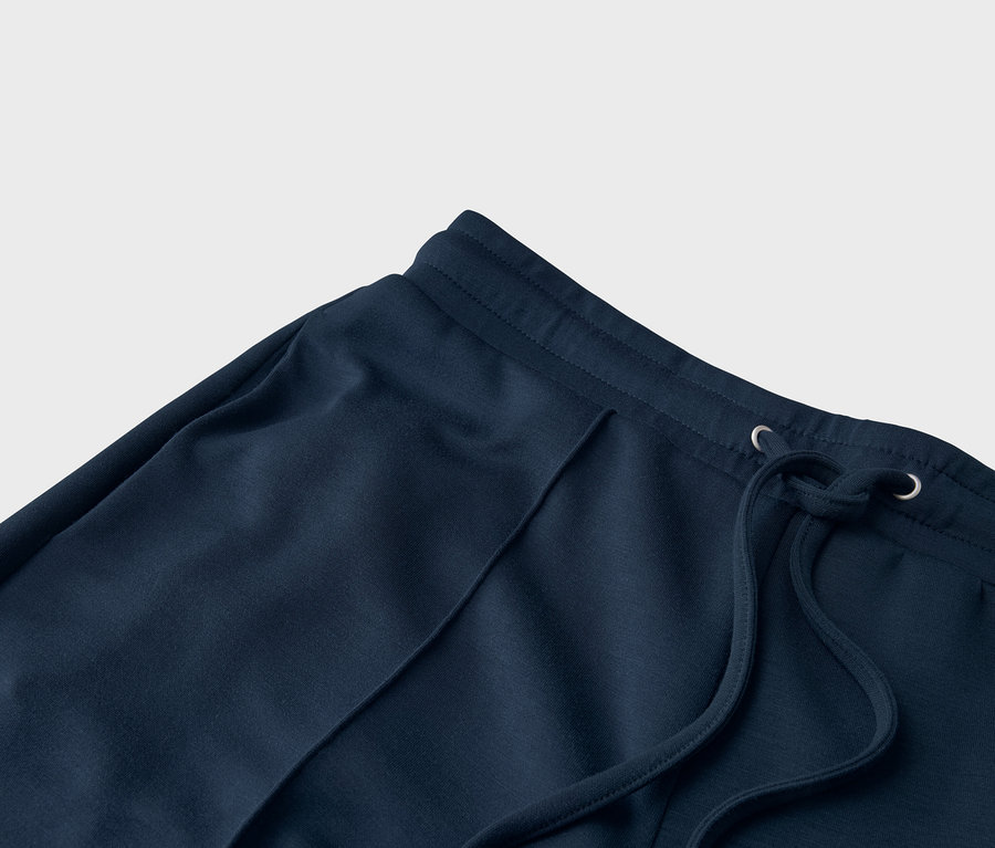 Egy sötétkék színű, húzózsinóros jogging alsó közeli képe.