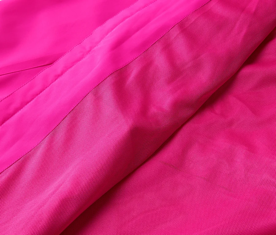 Rózsaszín anyag közeli képe sima és texturált felületekkel.