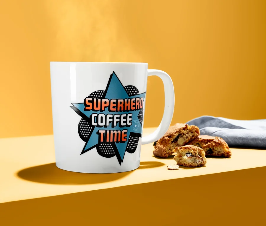 Fehér Színváltós bögre "COFFEE" felirattal, kekszek mellett.
