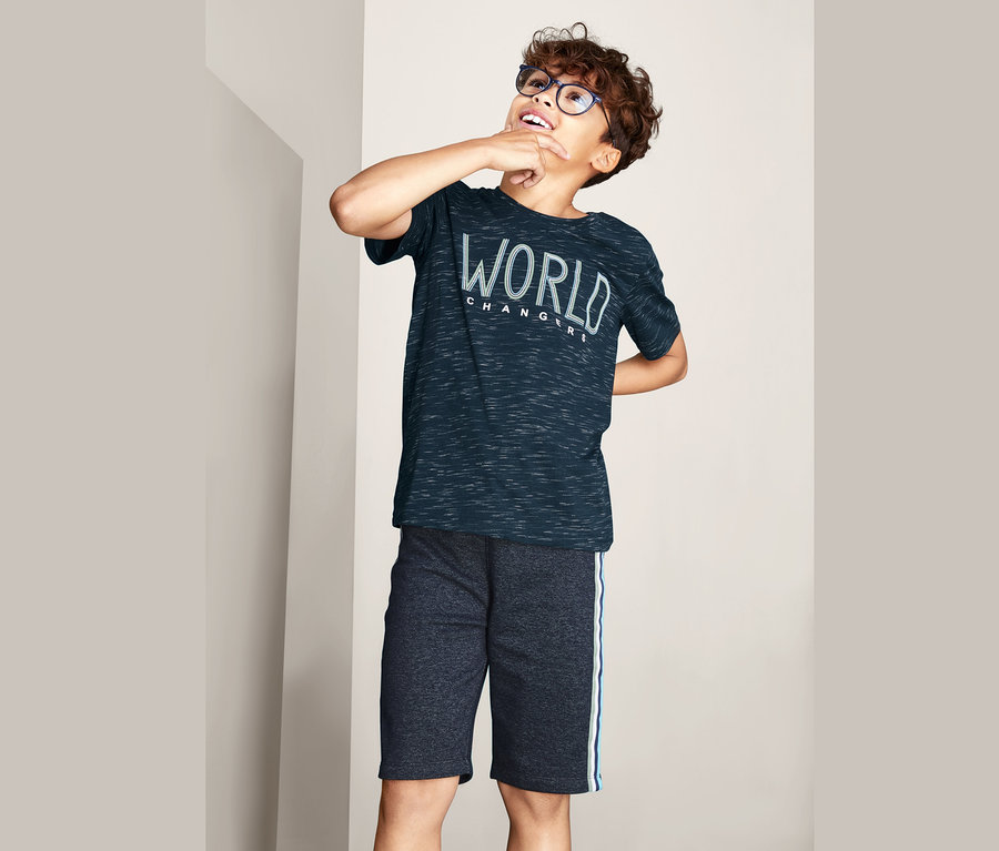 Egy szemüveges fiú egy 2 darabos pólókészlet egyik pólóját viseli.