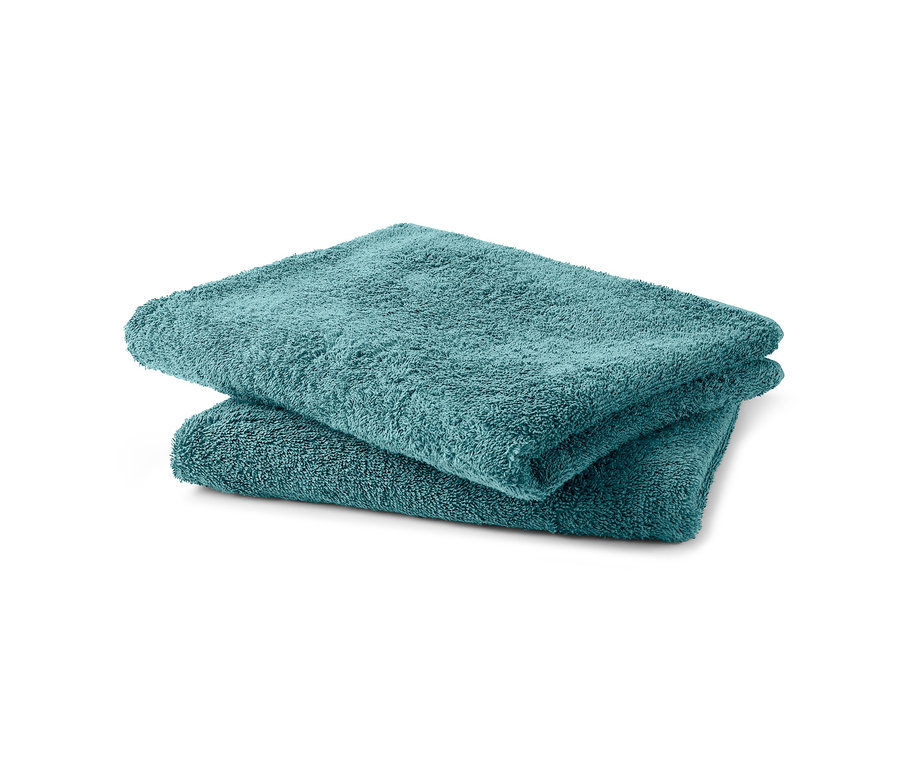 Két egymásra hajtott türkiz frottír törölköző.