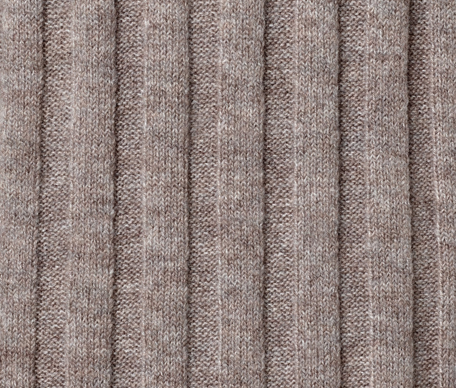 Közeli kép egy taupe színű, gyapjú kötött női ruháról.