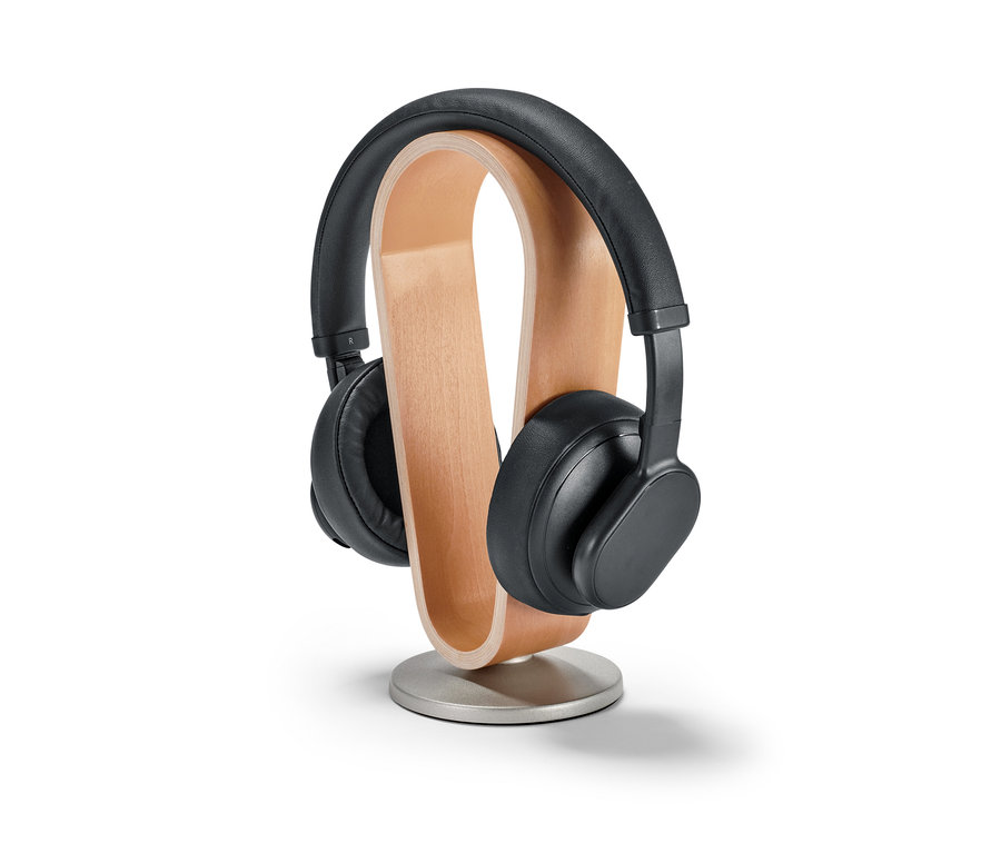 Fekete fejhallgató egy fa/fém fejhallgató tartó állványon.