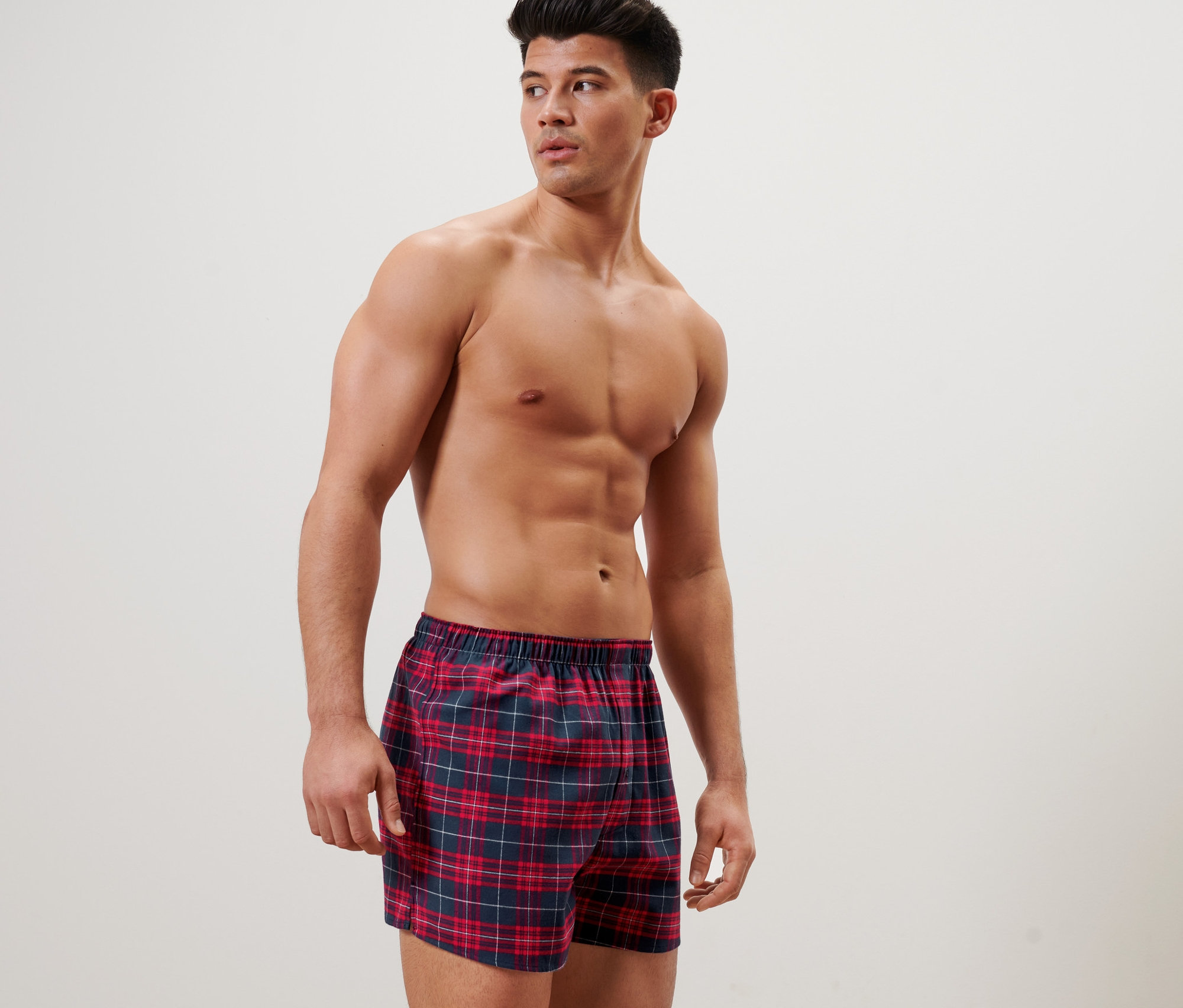Férfi pózol kockás flanel boxeralsóban.