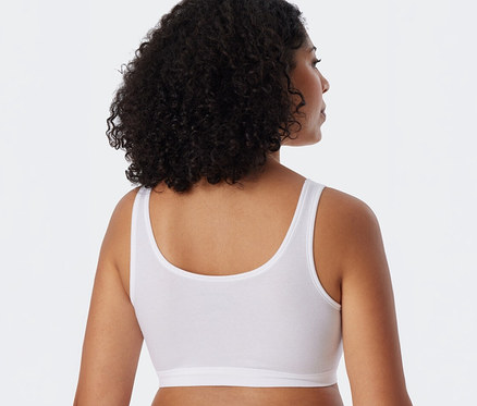 Hátulról látható nő, feje enyhén jobbra fordulva, fehér SCHIESSER bustier melltartót visel.