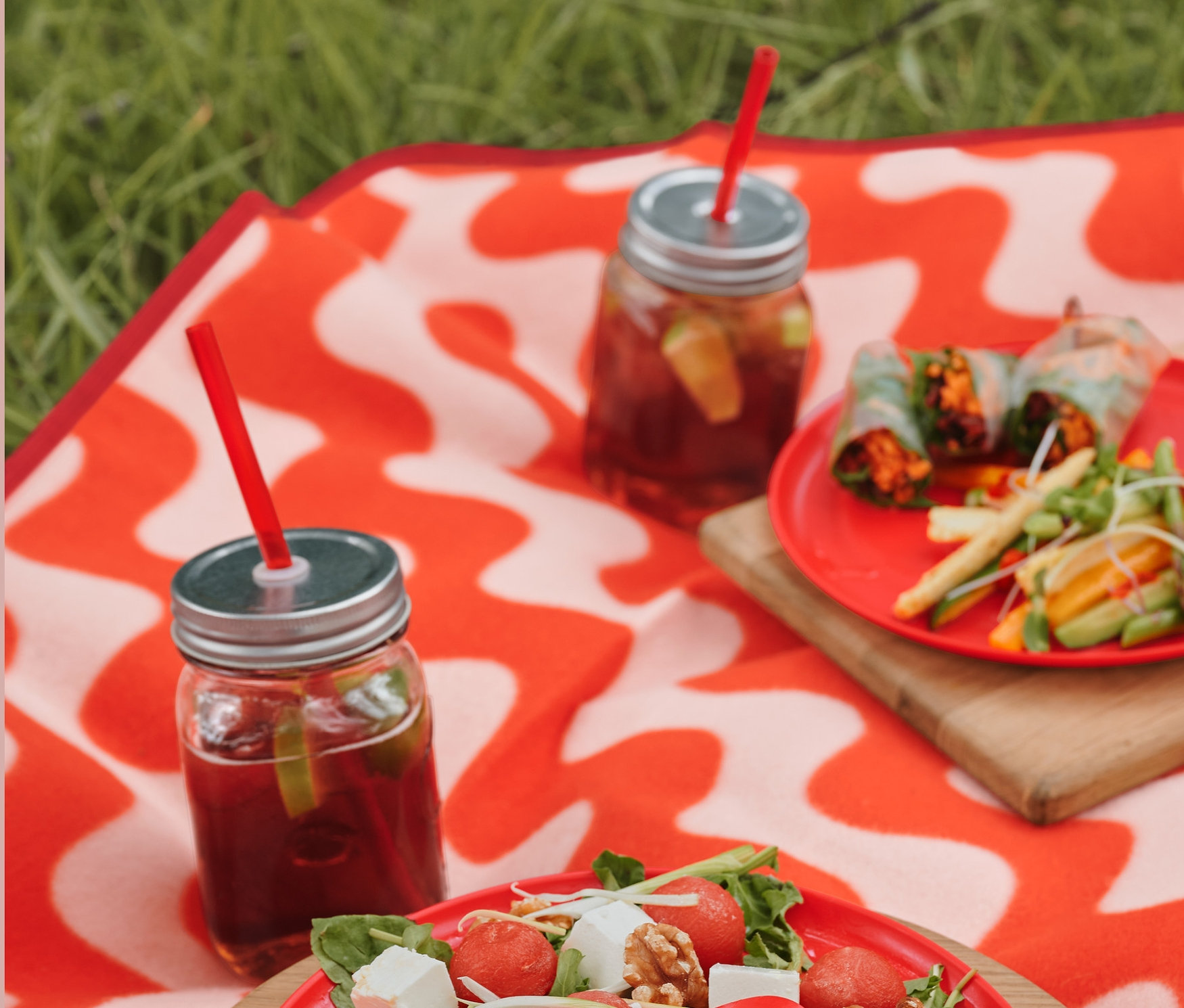 Egy XL-es pikniktakarón salátástányér, To-Go evőeszközkészlet tokkal, poharak italokkal és 4 műanyag szívószál tisztítókefével.