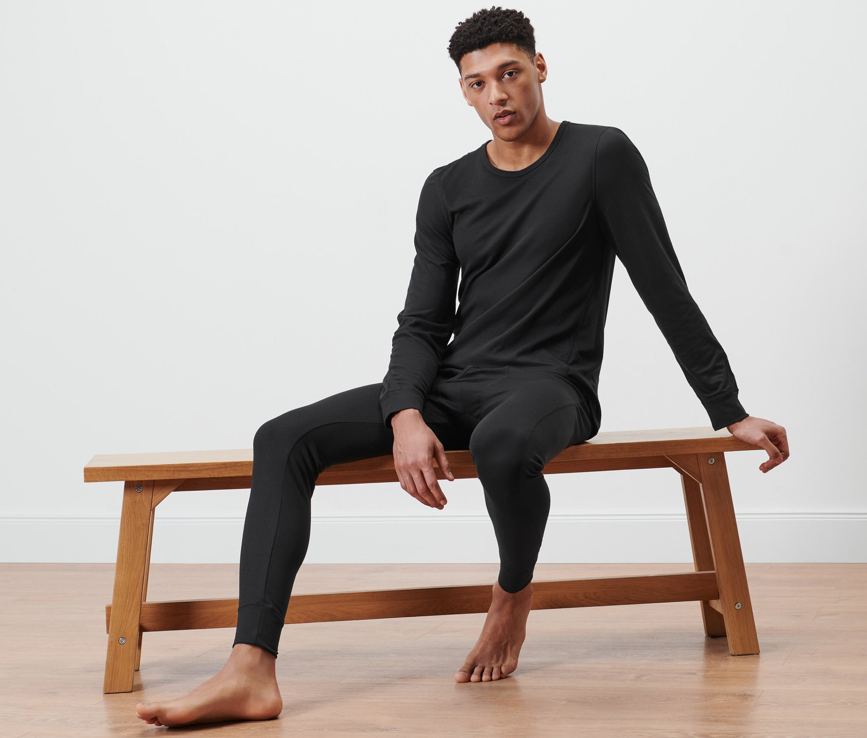Férfi ül egy padon, fekete funkcionális termo alsóruházatot visel.