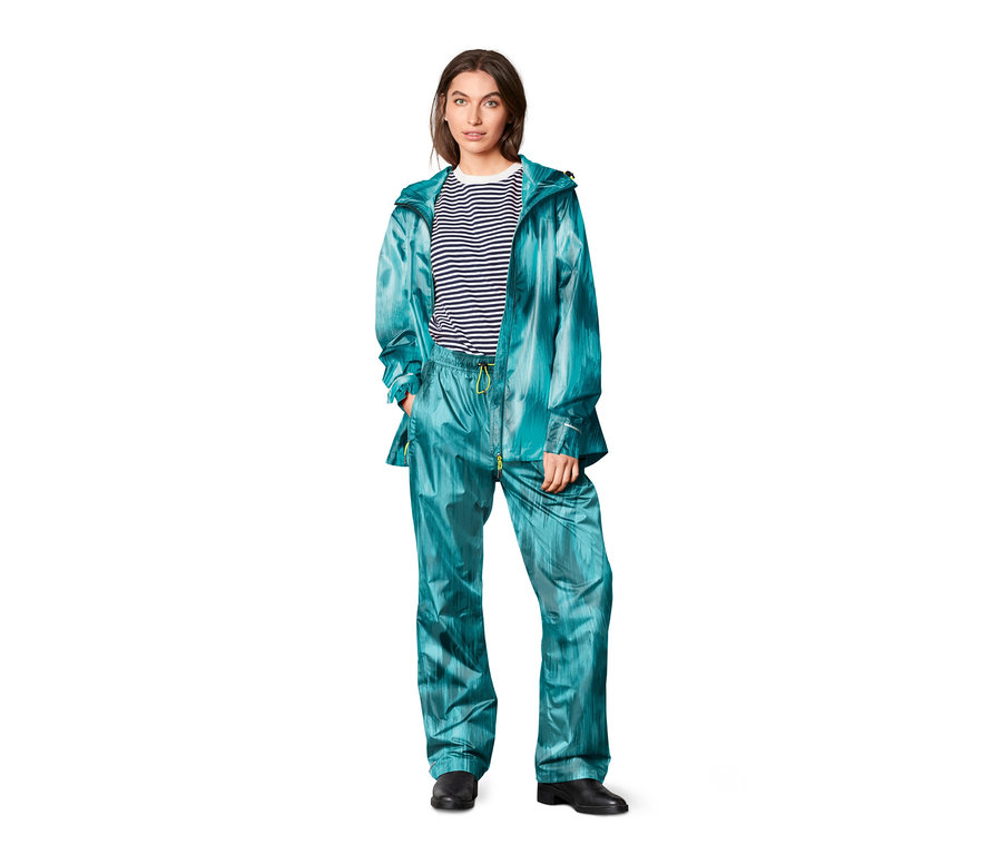 Nő visel kabátot és Unisex esőnadrágot, mintás, türkiz.