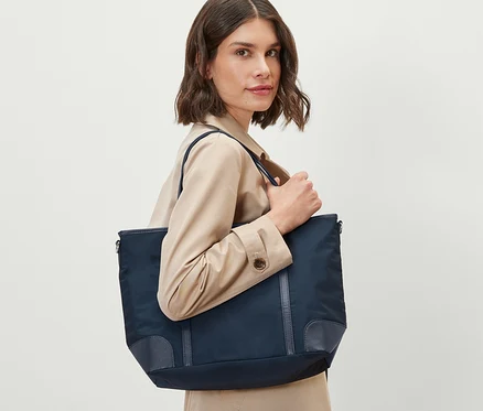 Nő tart egy sötétkék női shopper táskát.