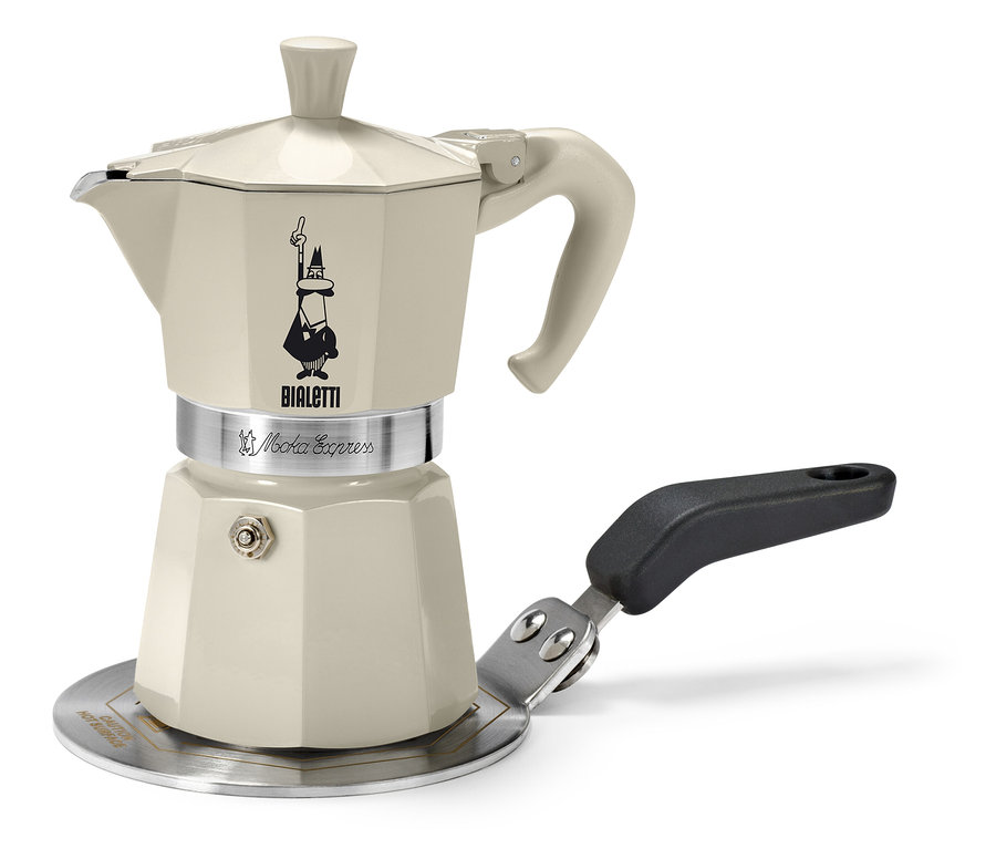 Egy bézs Bialetti kotyogós kávéfőző áll egy 13 cm-es Bialetti indukciós átalakítólapon.
