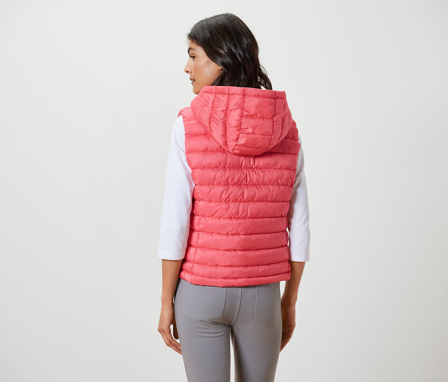 Nő visel kapucnis steppelt mellényt.