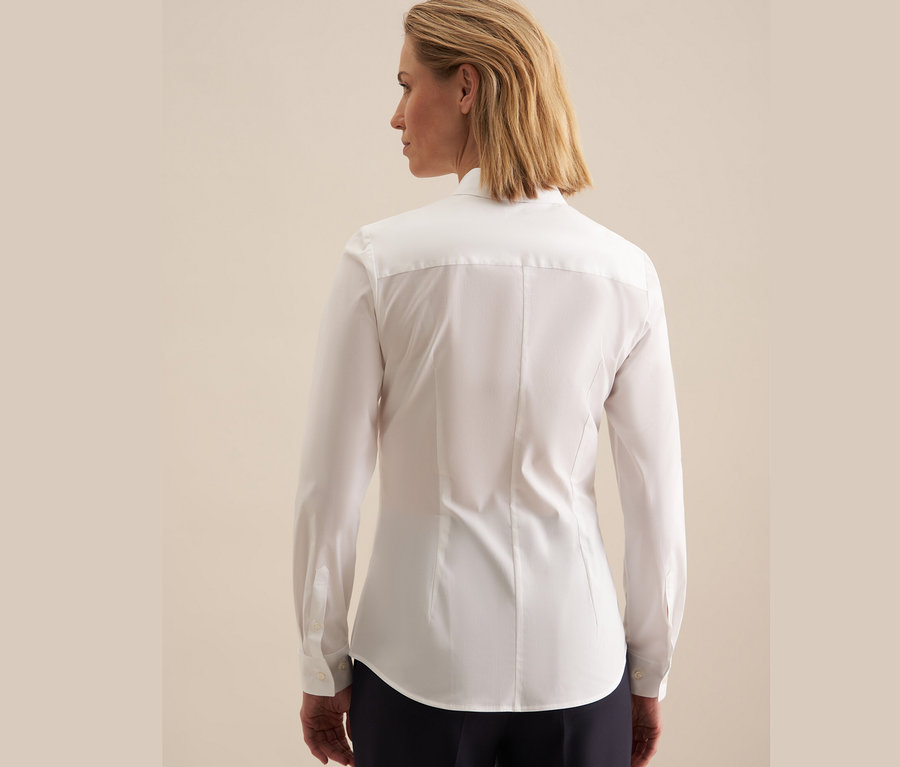 Hátulnézetből egy szőke nő látható, aki egy fehér Seidensticker slimfit blúzt visel.