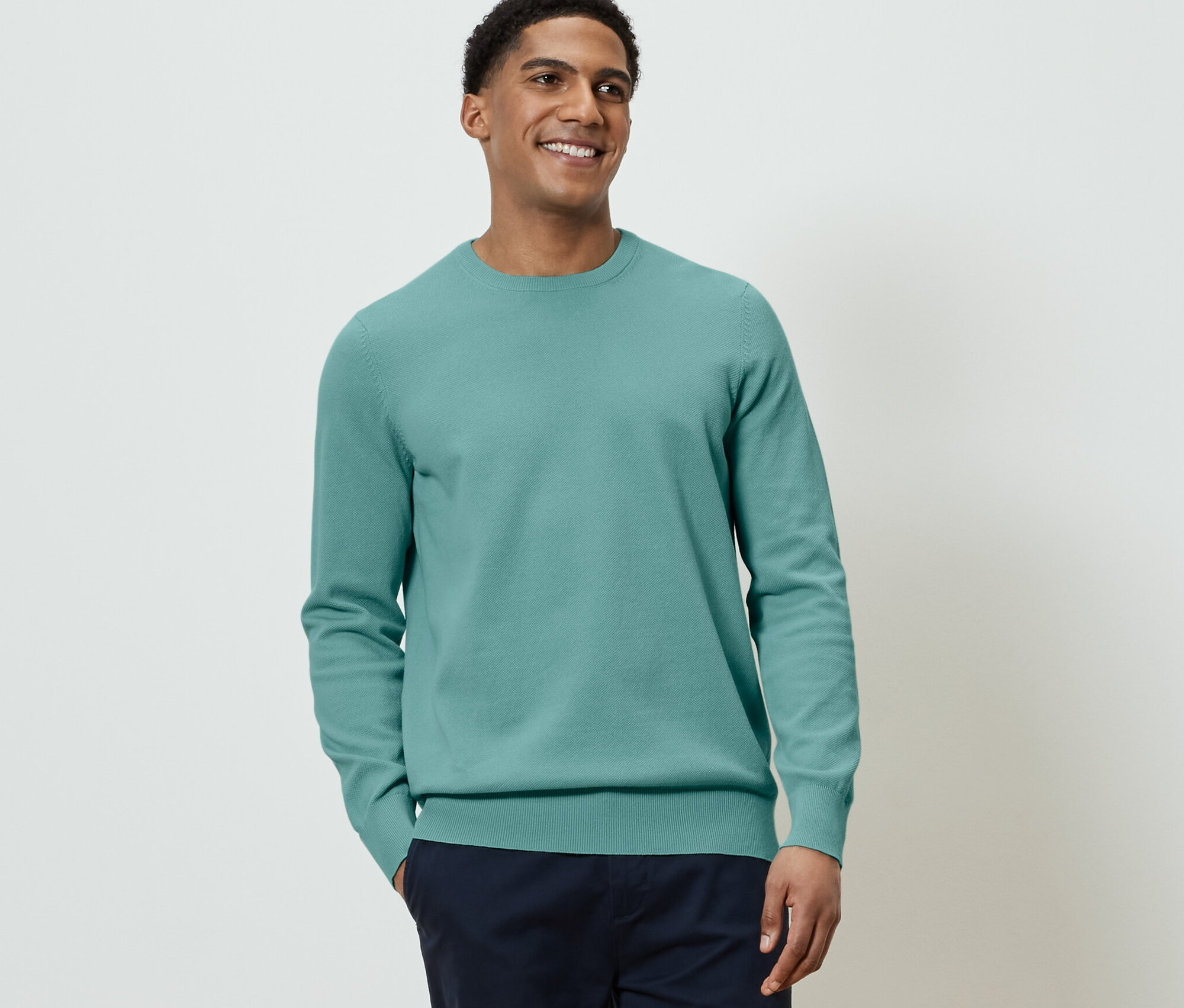 Férfi kötött pulóvert visel.