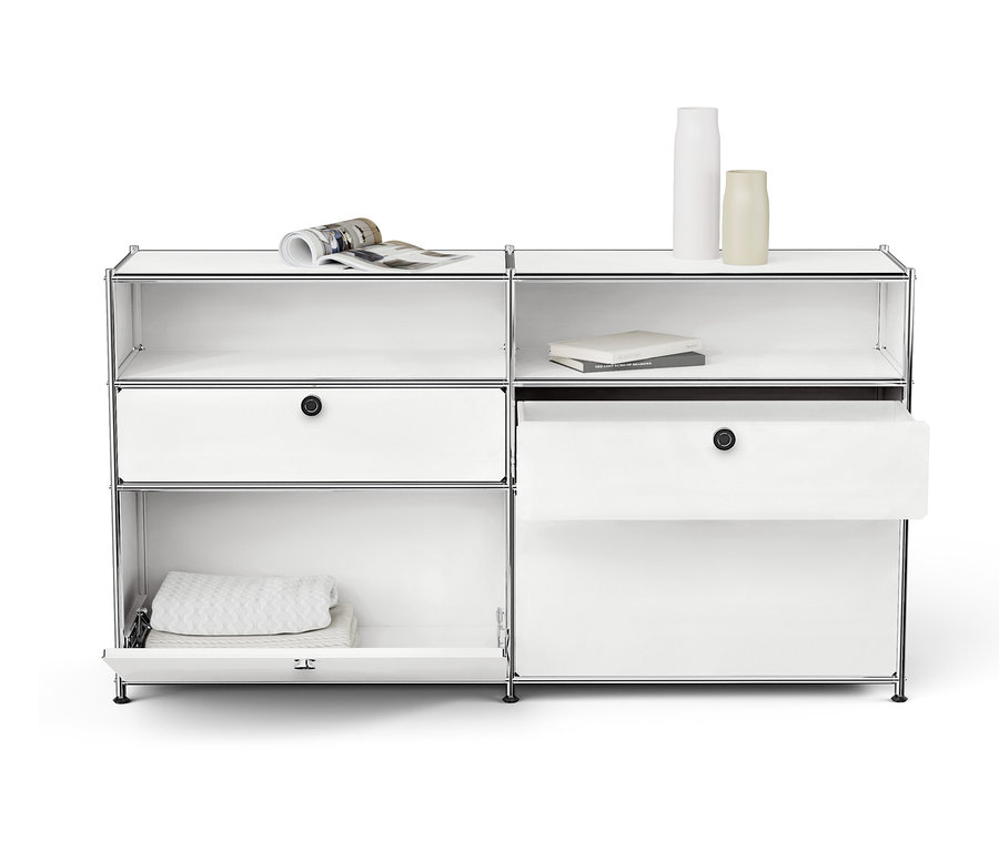 Fehér, moduláris tárolórendszer nyitott és zárt rekeszekkel, melyeken könyvek, vázák és egy folyóirat található.