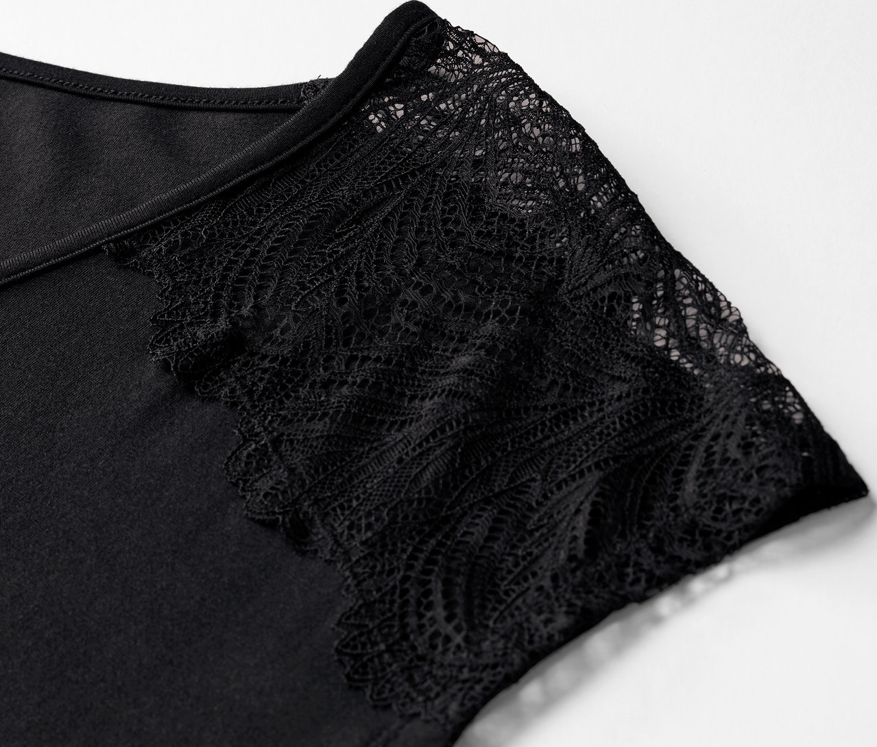 Egy fekete, csipkeujjú rövid pizsama részlete.