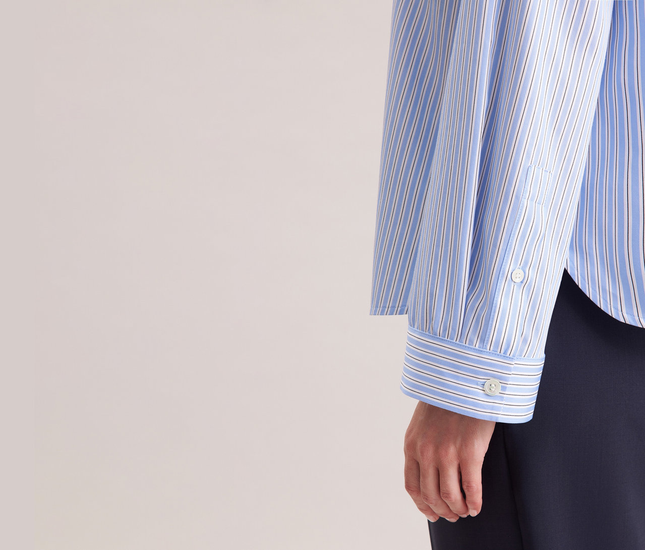 Nő visel egy kék-fehér csíkos Seidensticker túlméretezett ingblúzt.