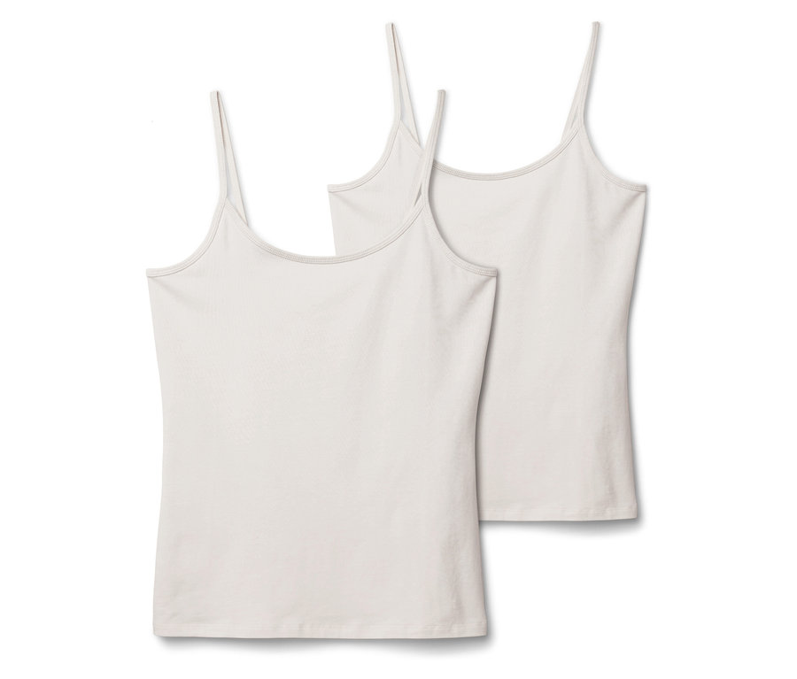 Két fehér, vékony pántos trikó egymás mellett fekszik fehér háttér előtt.