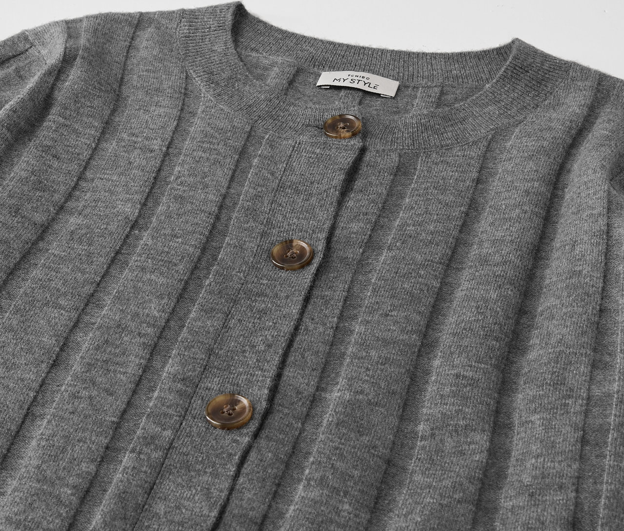 Egy gombos, szürke kardigán részlete.