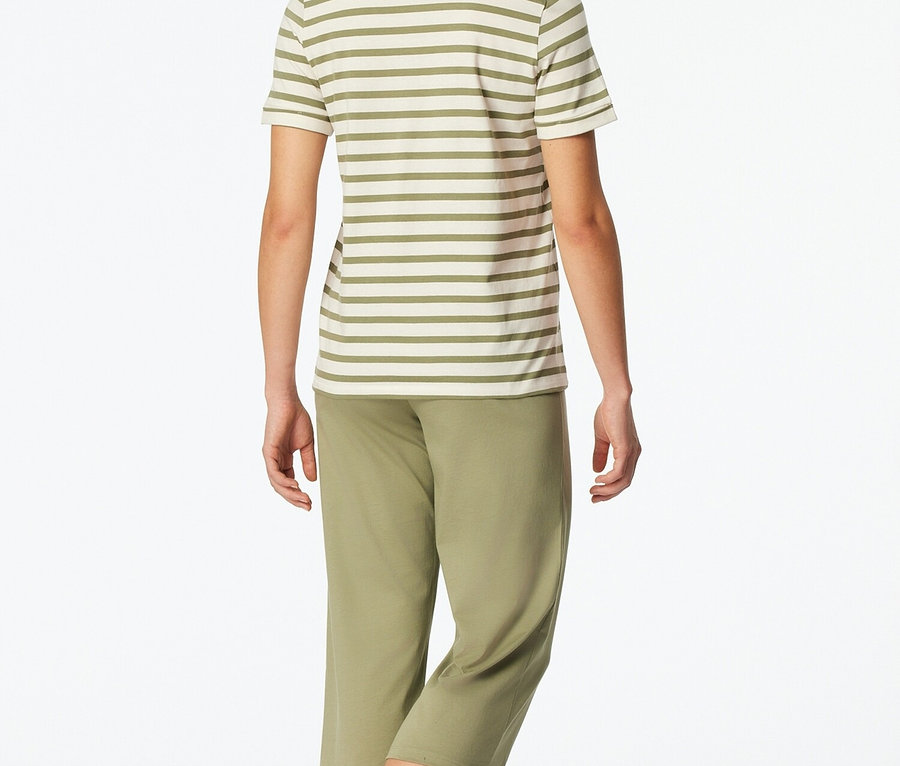 Nő hátulról csíkos felsőben és zöld nadrágban.