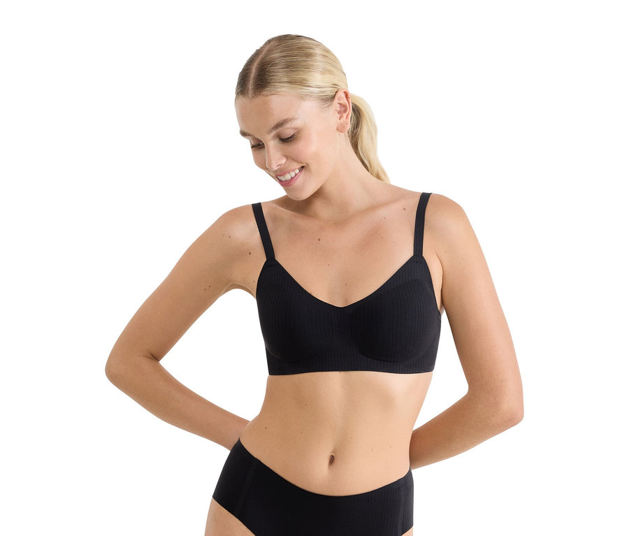 Nő fekete bordázott melltartót és alsóneműt visel.