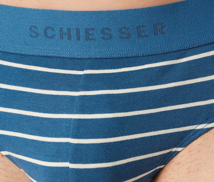 Férfi visel kék-fehér csíkos SCHIESSER Rio alsót. A kék derékpánton SCHIESSER logó látható.